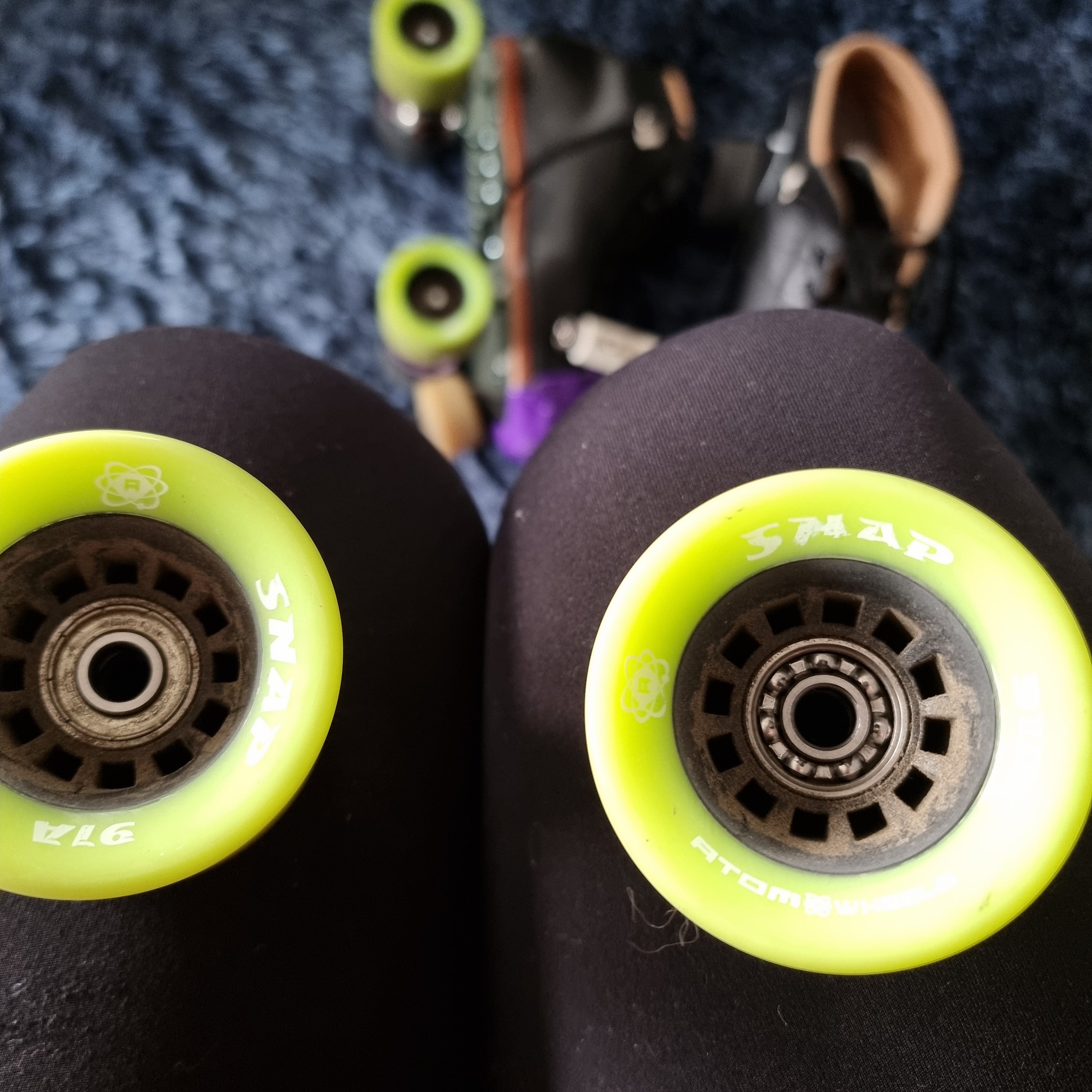 Roller skate wheels with bearings. One wheel has sealed bearings, the other wheel the ball bearings are visible, as the bearing shield is missing.